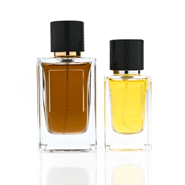 HUA0382 perfume bottle, square cubic clear glass body with architectural vertical fluting flutes, shiny gold neck and centered gold rectangular label, diamond knurled cylindrical plastic cap in deep brown or black matte finishes, luxury niche fragrance packaging design available in 50ml and 100ml