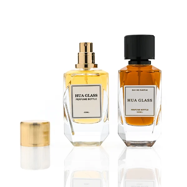 HUA0383 perfume bottle, multi-faceted geometric cut clear glass body with centered paper label, vertical ribbed cylindrical aluminum cap and matching neck ring in radiant gold or shiny black, modern architectural luxury fragrance packaging design in 50ml