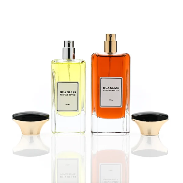 HUA0384 perfume bottle, flat rectangular cuboid clear glass body with beveled edges and centered paper label, unique dual-tone funnel-shaped plastic cap with glossy black top and gold body, luxury fragrance packaging design available in 50ml and 100ml
