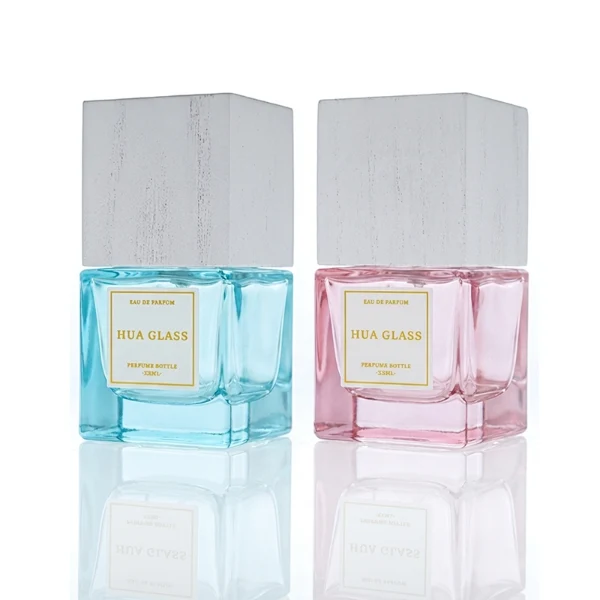 HUA0385 perfume bottle, square cubic clear glass body with heavy bottom and centered paper label, tall block cubic wooden cap showing organic wood grain textures in charcoal black or light grey-white, modern minimalist luxury fragrance packaging design available in 30ml, 50ml, and 100ml