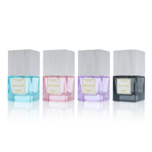 HUA0385 perfume bottle, square cubic clear glass body with heavy bottom and centered paper label, tall block cubic wooden cap showing organic wood grain textures in charcoal black or light grey-white, modern minimalist luxury fragrance packaging design available in 30ml, 50ml, and 100ml