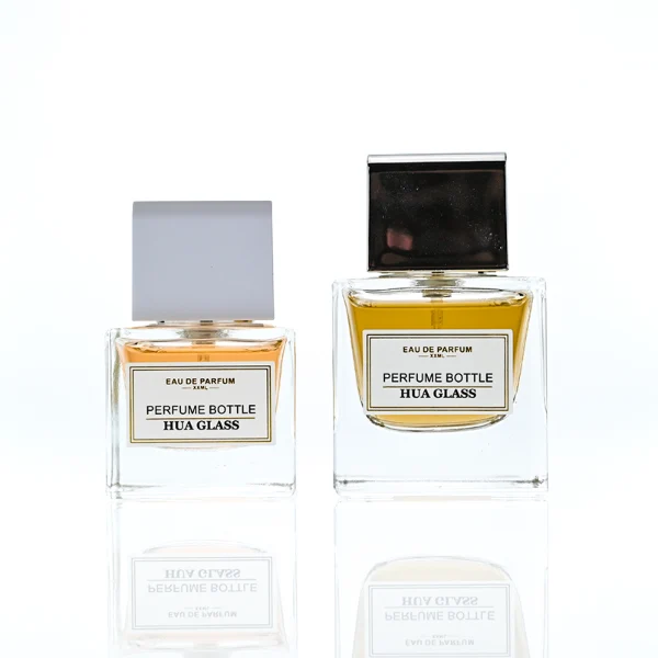 HUA0386 perfume bottle, flat rectangular cuboid clear glass body with heavy bottom and centered paper label, square cubic magnetic plastic cap in matte silver-grey or glossy black finishes, premium magnetic closure fragrance packaging design available in 30ml, 50ml, and 100ml