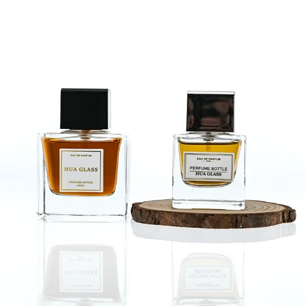 HUA0386 perfume bottle, flat rectangular cuboid clear glass body with heavy bottom and centered paper label, square cubic magnetic plastic cap in matte silver-grey or glossy black finishes, premium magnetic closure fragrance packaging design available in 30ml, 50ml, and 100ml