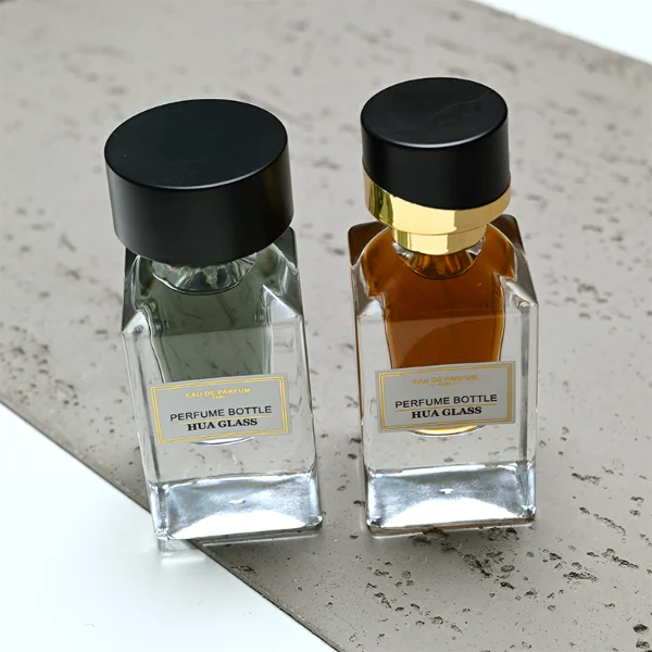 HUA0387 perfume bottle, fluted rectangular cuboid glass body with vibrant translucent amber-to-blue or pink-to-purple ombre gradient coating and centered paper label, unique slanted-top shiny black plastic cap with tiered gold neck, luxury Art Deco fragrance packaging design in 30ml