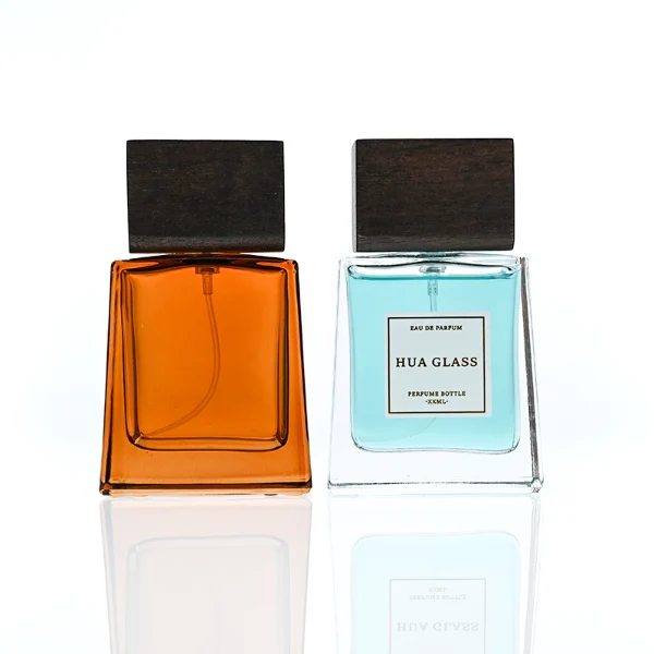 HUA0388 perfume bottle, flat trapezoidal clear glass body with heavy bottom and centered paper label, flat rectangular block wooden cap showing organic dark wood grain textures, luxury minimalist fragrance packaging design available in 50ml and 100ml