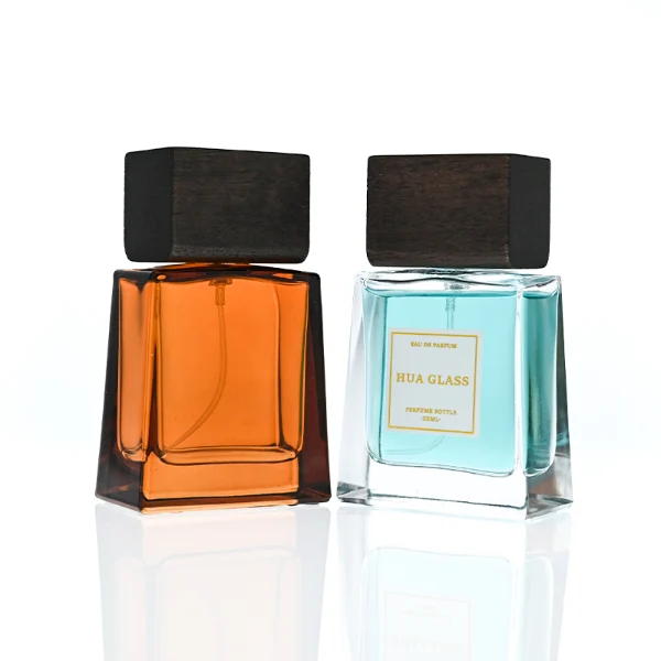 HUA0388 perfume bottle, flat trapezoidal clear glass body with heavy bottom and centered paper label, flat rectangular block wooden cap showing organic dark wood grain textures, luxury minimalist fragrance packaging design available in 50ml and 100ml