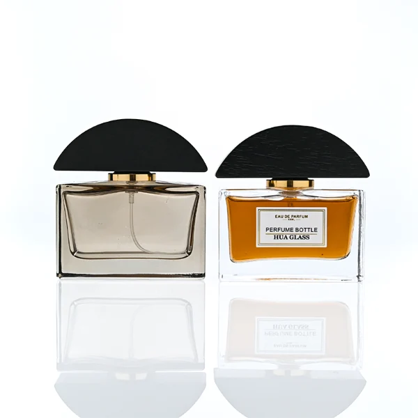 HUA0400 perfume bottle, flat rectangular cuboid glass body in transparent clear or translucent smoky black with heavy bottom and centered paper label, unique semi-circular arch-shaped wooden cap in matte black texture with shiny gold neck, modern luxury fragrance packaging design available in 30ml, 50ml, and 100ml