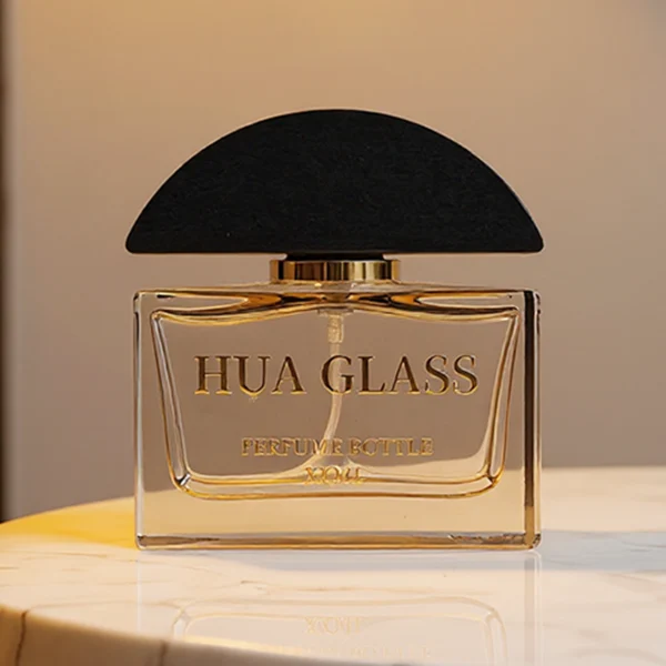 HUA0400 perfume bottle, flat rectangular cuboid glass body in transparent clear or translucent smoky black with heavy bottom and centered paper label, unique semi-circular arch-shaped wooden cap in matte black texture with shiny gold neck, modern luxury fragrance packaging design available in 30ml, 50ml, and 100ml