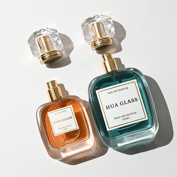HUA0402 perfume bottle, flat squircle rounded square glass body with translucent coating in blue, green, purple or yellow and centered paper label, multi-faceted crystal-clear transparent spherical plastic ball cap with an engraved decorative shiny gold neck, romantic luxury fragrance packaging design available in 30ml, 50ml, and 100ml