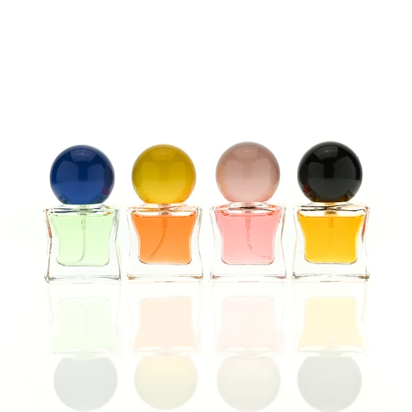 HUA0403 perfume bottle, compact cubic square glass body with translucent coating in blue, pink, black, green or brown and centered printed black brand logo, sleek spherical dome plastic cap in shiny gold finish, modern luxury fragrance packaging design in 15ml