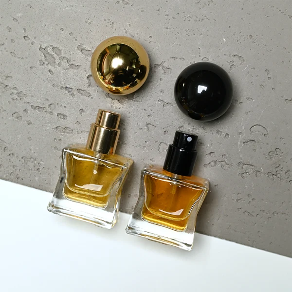 HUA0403 perfume bottle, compact cubic square glass body with translucent coating in blue, pink, black, green or brown and centered printed black brand logo, sleek spherical dome plastic cap in shiny gold finish, modern luxury fragrance packaging design in 15ml