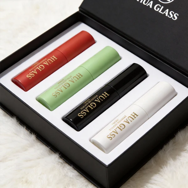 In the file HUA0404 Perfume Bottle – Slim Cylindrical Travel Atomizer with Multi-Color Matte Plastic Sleeve and Internal Glass Vial, four slim cylindrical travel atomizers are arranged inside a black gift box. The atomizers feature matte finishes in red, light green, glossy black, and white, each branded with a golden "HUA GLASS" logo.