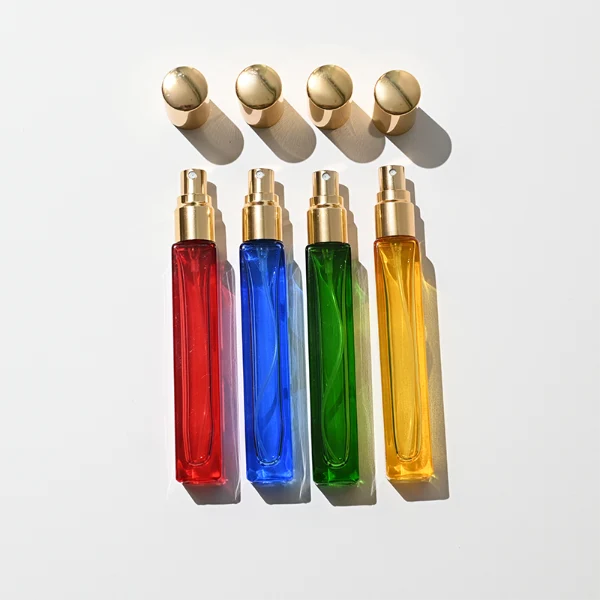 HUA0406 perfume bottle, slim cylindrical glass travel atomizer with transparent multi-color glass body in green, blue, red or yellow, featuring a luxury gold cylindrical zamak cap, modern minimalist travel fragrance packaging design available in 10ml