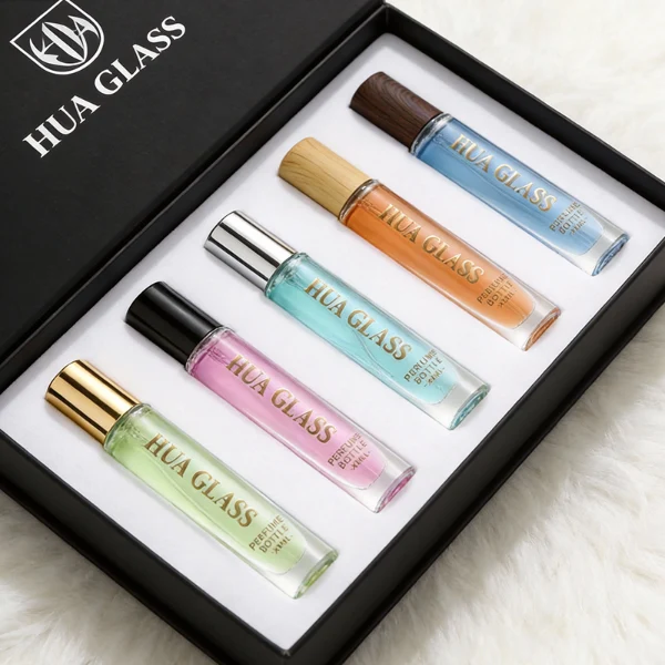 HUA0407 perfume bottle, slim cylindrical glass travel atomizer with tinted semi-transparent multi-color glass body in smoky black, orange or green featuring a subtle brand logo, topped with a luxury gold or black cylindrical zamak cap, modern minimalist travel fragrance packaging available in 10ml