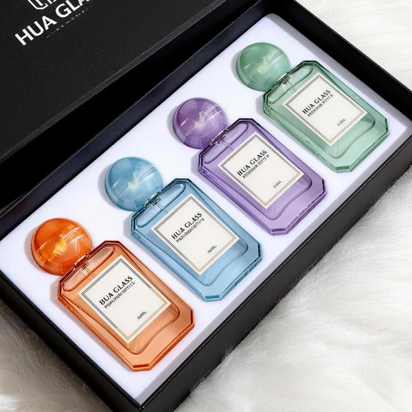HUA0409 perfume bottle, luxury square glass bottle with beveled edges and transparent multi-color finish in orange, blue, purple, or green, featuring a rectangular paper label and a hollow round ball plastic cap with a marble pattern covering the internal sprayer, modern elegant fragrance packaging design available in 30ml, 50ml, and 100ml