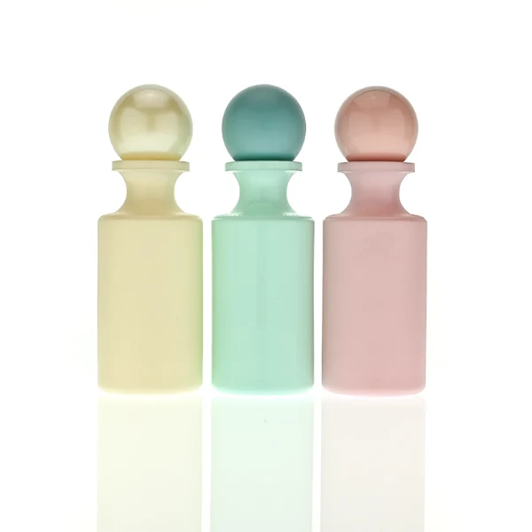 HUA0413 perfume bottle, luxury apothecary-style cylindrical glass bottle with solid opaque glossy finish in blue, green, pink, or ivory, featuring a narrow neck and a matching large round ball plastic cap, modern elegant fragrance packaging design available in 30ml, 50ml, and 100ml