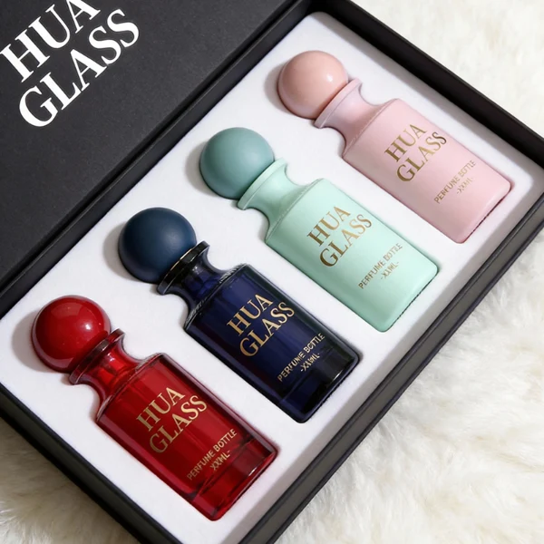HUA0413 perfume bottle, luxury apothecary-style cylindrical glass bottle with solid opaque glossy finish in blue, green, pink, or ivory, featuring a narrow neck and a matching large round ball plastic cap, modern elegant fragrance packaging design available in 30ml, 50ml, and 100ml