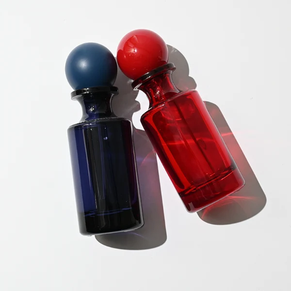 HUA0413 perfume bottle, luxury apothecary-style cylindrical glass bottle with solid opaque glossy finish in blue, green, pink, or ivory, featuring a narrow neck and a matching large round ball plastic cap, modern elegant fragrance packaging design available in 30ml, 50ml, and 100ml