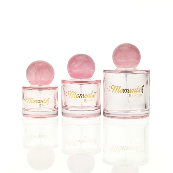 ]HUA0414 perfume bottle, luxury short cylindrical glass bottle with transparent pink finish, featuring a printed gold logo, a pink-colored collar, and a large round ball resin cap with a pink marble swirl pattern, modern elegant fragrance packaging design available in 30ml, 50ml, and 100ml