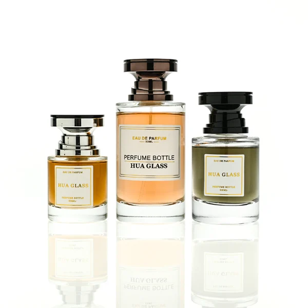 HUA0415 perfume bottle, luxury heavy-base cylindrical glass bottle with high-transparency finish showing colored liquid, featuring a gold-bordered square paper label and a unique layered hourglass-shaped plastic cap, modern elegant fragrance packaging design available in 30ml, 50ml, and 100ml