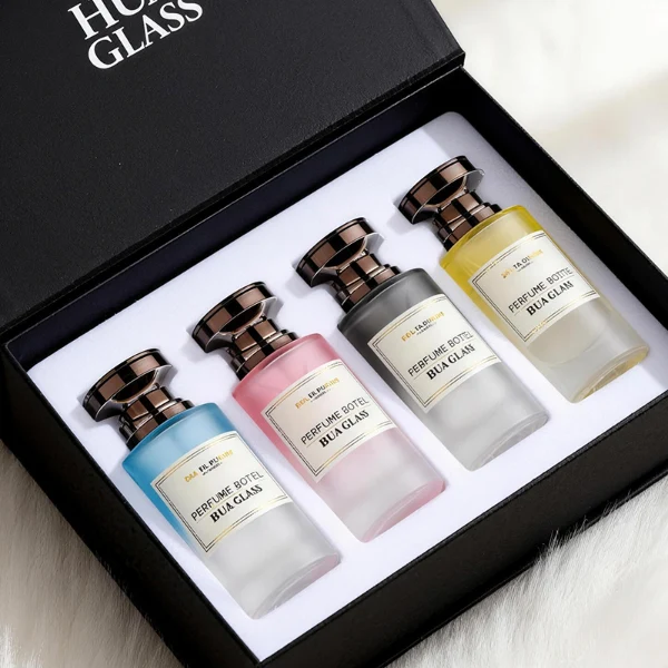 HUA0415 perfume bottle, luxury heavy-base cylindrical glass bottle with high-transparency finish showing colored liquid, featuring a gold-bordered square paper label and a unique layered hourglass-shaped plastic cap, modern elegant fragrance packaging design available in 30ml, 50ml, and 100ml