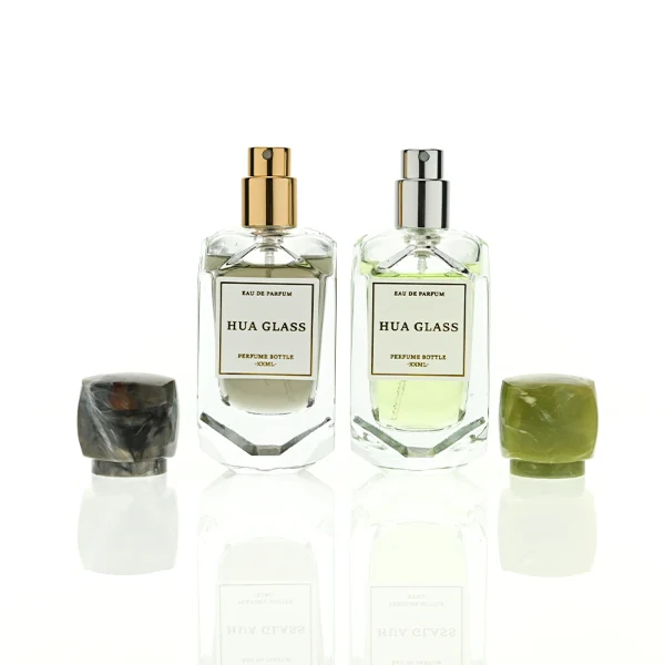 HUA0416 perfume bottle, luxury square glass bottle with a pentagonal faceted geometric shape and high-transparency finish showing colored liquid, featuring a bordered square paper label and a unique faceted square block resin cap with a marble swirl pattern, modern elegant fragrance packaging design available in 30ml and 50ml
