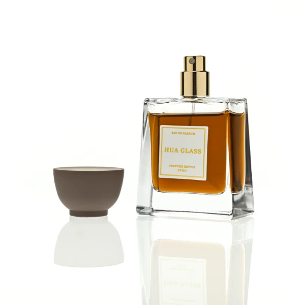 HUA0418 perfume bottle, luxury trapezoidal square glass bottle with a frosted matte multi-color finish in green, pink, blue, or yellow, featuring a bordered square paper label and a unique glossy black tapered cup-shaped plastic cap, modern elegant fragrance packaging design available in 30ml, 50ml, and 100ml