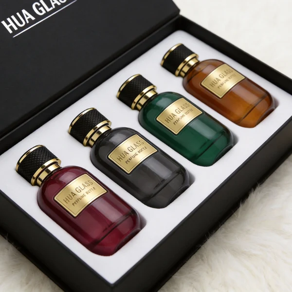 HUA0420 perfume bottle, luxury 100ml rounded oval glass bottle with translucent deep multi-color finish in red, grey, green, or brown, featuring a gold-colored aluminum label and a black textured leather-wrapped plastic cap with gold-colored trim, modern elegant fragrance packaging design