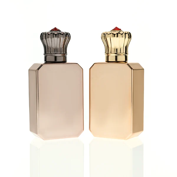 HUA0422 perfume bottle, luxury electroplated beveled corner square glass bottle with mirror gloss finish in gold or rose gold, featuring a unique crown-shaped zamak cap with a red gemstone tip, premium regal fragrance packaging design available in 30ml, 50ml, and 100ml