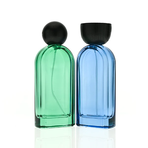 HUA0423 perfume bottle, luxury arch-shaped flat oval glass bottle with translucent finish in green or blue, featuring a dark-colored neck collar and a unique flat-topped glossy black wooden cap, modern elegant fragrance packaging design available in 30ml, 50ml, and 100ml