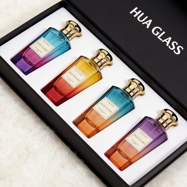 HUA0427 perfume bottle, luxury heavy-base tapered faceted glass bottle with high-transparency finish showing colored liquid, featuring a gold-bordered square paper label and a unique wavy crown-shaped zamak cap with a high-shine gold or silver finish, modern elegant fragrance packaging design available in 50ml and 75ml