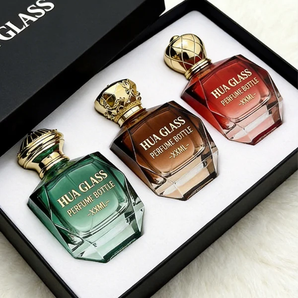 HUA0428 perfume bottle, luxury heavy-base multi-faceted angular square glass bottle with high-transparency finish showing colored liquid, featuring a matching gold-colored neck collar and an ornate crown-style zamak cap with a high-shine gold finish, premium regal fragrance packaging design available in 30ml, 50ml, and 100ml