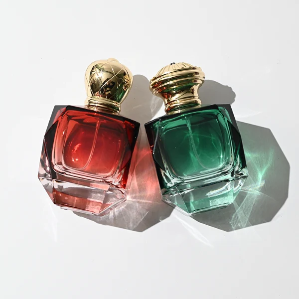 HUA0428 perfume bottle, luxury heavy-base multi-faceted angular square glass bottle with high-transparency finish showing colored liquid, featuring a matching gold-colored neck collar and an ornate crown-style zamak cap with a high-shine gold finish, premium regal fragrance packaging design available in 30ml, 50ml, and 100ml