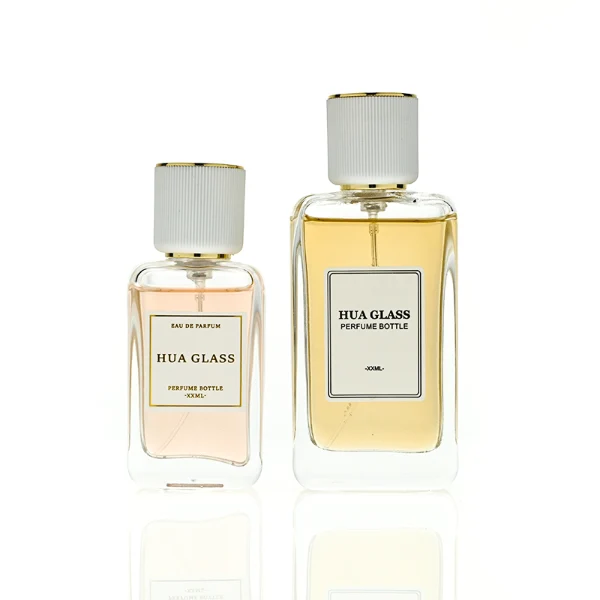 HUA0431 perfume bottle, luxury heavy-base flat rectangular glass bottle with high-transparency finish showing colored liquid, featuring a bordered square paper label and a minimalist white cylindrical plastic cap with gold-colored trim, modern elegant fragrance packaging design available in 30ml, 50ml, and 100ml