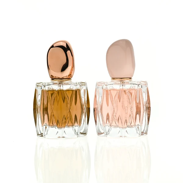 HUA0432 perfume bottle, luxury heavy-base rounded square glass bottle with wavy sculpted embossed patterns and high-transparency clear finish, featuring a unique irregular pebble-shaped plastic cap with a mirror-shine glossy rose gold finish, modern elegant fragrance packaging design