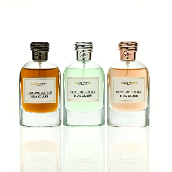HUA0434 perfume bottle, luxury 100ml heavy-base round cylindrical glass bottle with high-transparency clear finish, featuring a bordered square paper label and a unique horizontal threaded cylindrical plastic cap with a mirror-shine metallic chrome finish, modern elegant fragrance packaging design