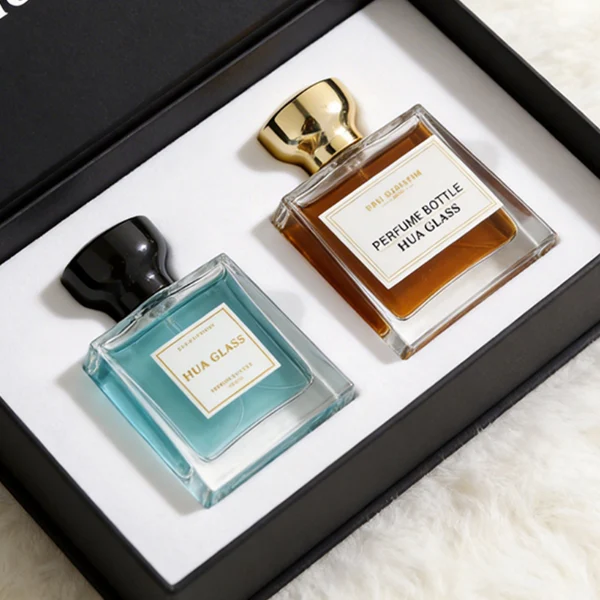 HUA0441 perfume bottle, luxury heavy-base trapezoidal glass bottle with high-transparency clear finish, featuring a bordered square paper label and a flared hourglass solid Zamak cap with a mirror-shine glossy finish, modern elegant fragrance packaging design available in 30ml, 50ml, and 100ml