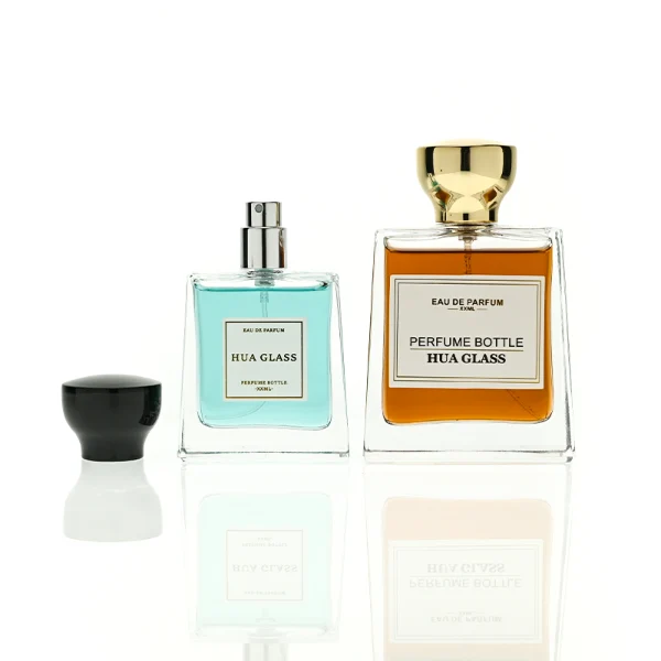 HUA0441 perfume bottle, luxury heavy-base trapezoidal glass bottle with high-transparency clear finish, featuring a bordered square paper label and a flared hourglass solid Zamak cap with a mirror-shine glossy finish, modern elegant fragrance packaging design available in 30ml, 50ml, and 100ml