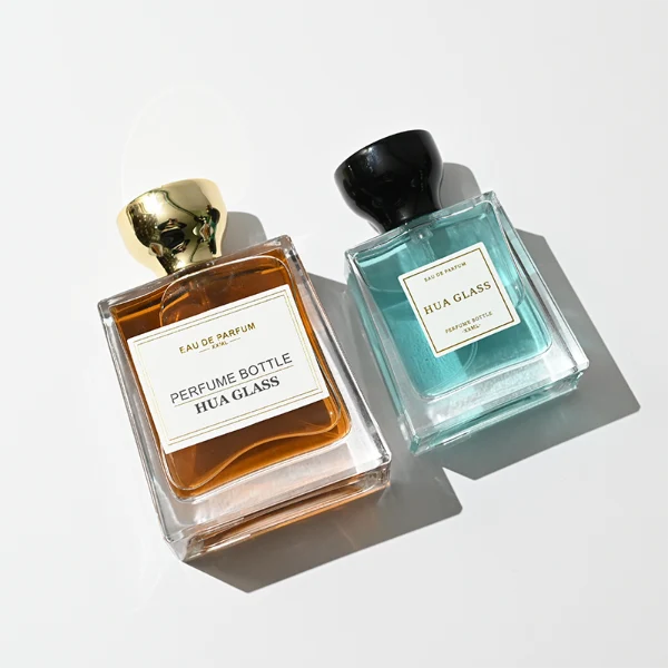 HUA0441 perfume bottle, luxury heavy-base trapezoidal glass bottle with high-transparency clear finish, featuring a bordered square paper label and a flared hourglass solid Zamak cap with a mirror-shine glossy finish, modern elegant fragrance packaging design available in 30ml, 50ml, and 100ml