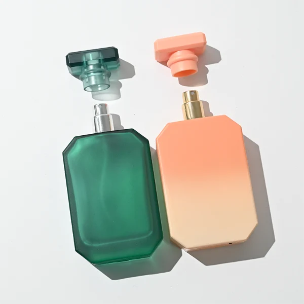 HUA0443 perfume bottle showcases a square angular glass body in vibrant frosted, solid, and gradient color options. It is crowned with artistic plastic caps featuring crown, cube, and diamond-cut shapes. Designed for wholesalers, it provides 30ml, 50ml, and 100ml choices, combining aesthetic variety with durable design for diverse fragrance lines.