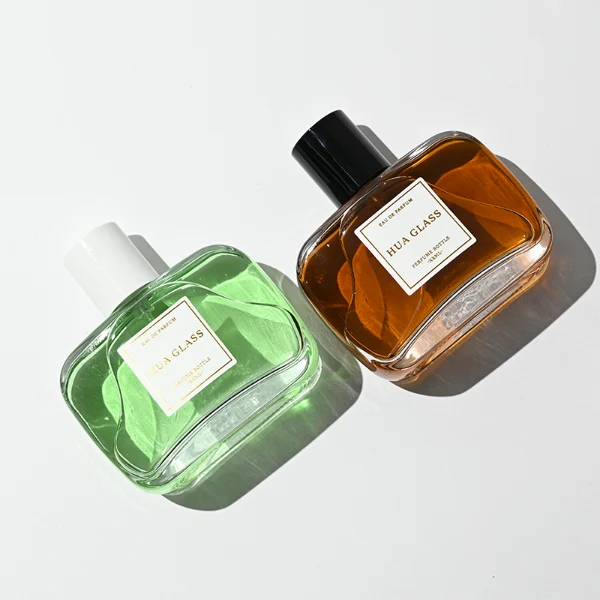 HUA0446 perfume bottle features a clear rounded and short rectangular glass body paired with a sleek cylindrical black or white plastic cap. Designed for wholesalers, it offers a 50ml capacity option, combining a modern minimalist style with durable functionality for diverse cosmetic fragrance lines.