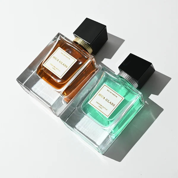 HUA0447 perfume bottle features a clear, thick-bottomed rectangular glass body with a modern cube-shaped plastic cap. Designed for wholesalers, it offers a 50ml capacity option, combining a sleek angular design with durable functionality for premium fragrance lines.
