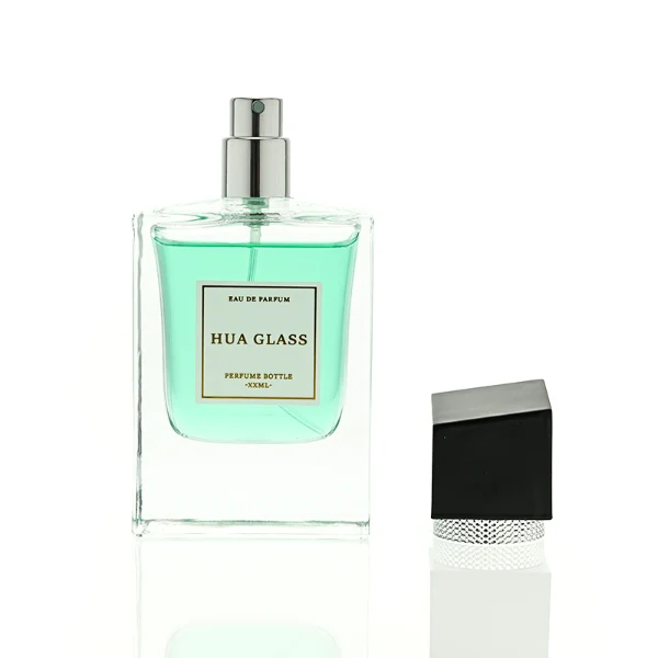 HUA0447 perfume bottle features a clear, thick-bottomed rectangular glass body with a modern cube-shaped plastic cap. Designed for wholesalers, it offers a 50ml capacity option, combining a sleek angular design with durable functionality for premium fragrance lines.