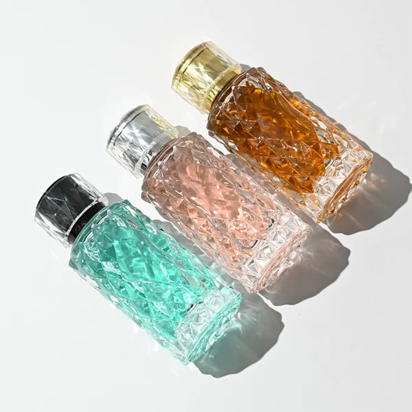 HUA0448 perfume bottle features a textured, diamond-patterned clear glass body paired with a matching cylindrical faceted plastic cap in black, silver, or gold. Designed for wholesalers, it offers 50ml and 100ml options, combining an elegant geometric design with practical durability for premium fragrance lines.