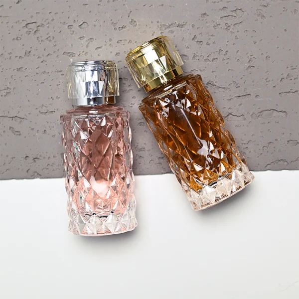 HUA0448 perfume bottle features a textured, diamond-patterned clear glass body paired with a matching cylindrical faceted plastic cap in black, silver, or gold. Designed for wholesalers, it offers 50ml and 100ml options, combining an elegant geometric design with practical durability for premium fragrance lines.