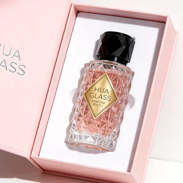 HUA0448 perfume bottle features a textured, diamond-patterned clear glass body paired with a matching cylindrical faceted plastic cap in black, silver, or gold. Designed for wholesalers, it offers 50ml and 100ml options, combining an elegant geometric design with practical durability for premium fragrance lines.