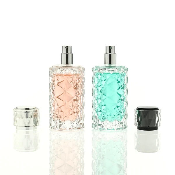 HUA0448 perfume bottle features a textured, diamond-patterned clear glass body paired with a matching cylindrical faceted plastic cap in black, silver, or gold. Designed for wholesalers, it offers 50ml and 100ml options, combining an elegant geometric design with practical durability for premium fragrance lines.