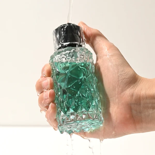 HUA0448 perfume bottle features a textured, diamond-patterned clear glass body paired with a matching cylindrical faceted plastic cap in black, silver, or gold. Designed for wholesalers, it offers 50ml and 100ml options, combining an elegant geometric design with practical durability for premium fragrance lines.