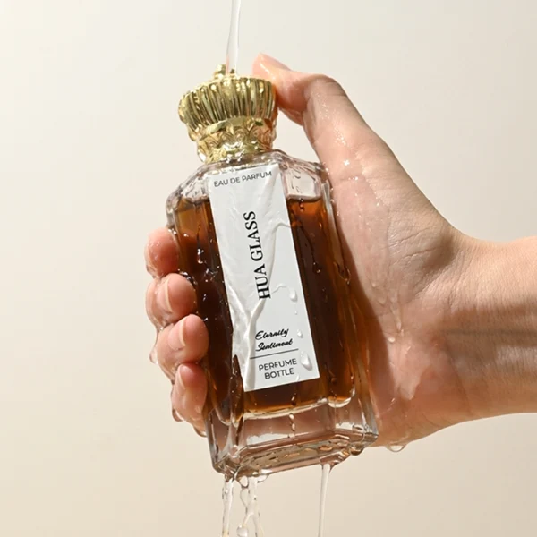 HUA0451 perfume bottle features a clear hexagonal glass body paired with an ornate crown-shaped plastic cap in gold or silver. Designed for wholesalers, it offers 50ml and 100ml choices, combining a regal aesthetic with structural durability for diverse fragrance lines.