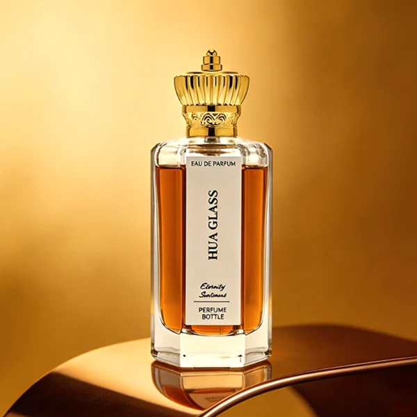 HUA0451 perfume bottle features a clear hexagonal glass body paired with an ornate crown-shaped plastic cap in gold or silver. Designed for wholesalers, it offers 50ml and 100ml choices, combining a regal aesthetic with structural durability for diverse fragrance lines.